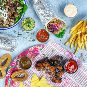 Mexican-style sharing meal with grilled bites, tacos, fries and dips
